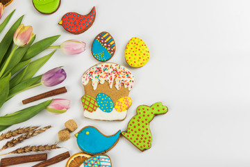 Tulips and gingerbread cookies on white background for Easter.