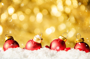 Fototapeta na wymiar Golden bokeh background with snow and red balls