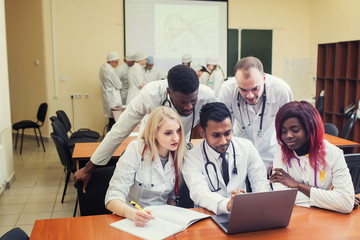 healthcare. A group mixedrace of student medical students communicates in front of a laptop. Discussion of the diagnosis