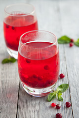 Two glass of punch with the mint on a wooden background