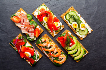Brushetta set on dark background. Variety of small sandwiches. D