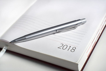 New Year 2018 office organizer calendar and sliver ballpen. Selective focus