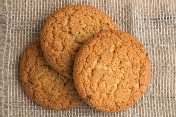Stack of freshly baked oat biscuits on the background of burlap