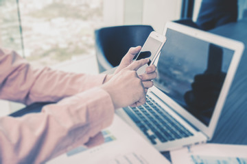 Casual dressed man using telephone and laptop.