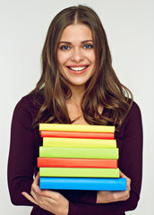smiling student girl holding pile, stack of books.