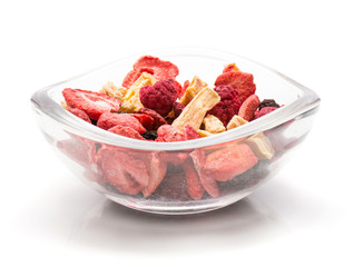 Freeze dried berries mix in a glass bowl isolated on white background.