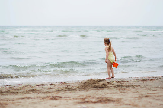 little girl on the beach sand. Little girl having fun on tropical ocean beach. Kid during family sea vacation.