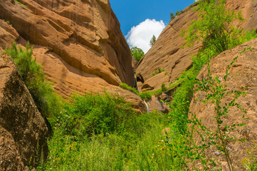 Steep rocks in mountains, blue sky and green vegetation in Kozhokelen