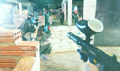 Paintball players aiming in opponents