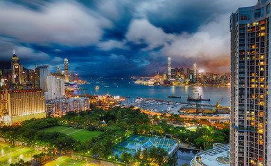 Naklejka premium HONG KONG - APRIL 2014: Beautiful Kowloon city skyline at night. Hong Kong attracts 25 million people annually