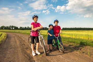 Sporty children in helmets with bikes