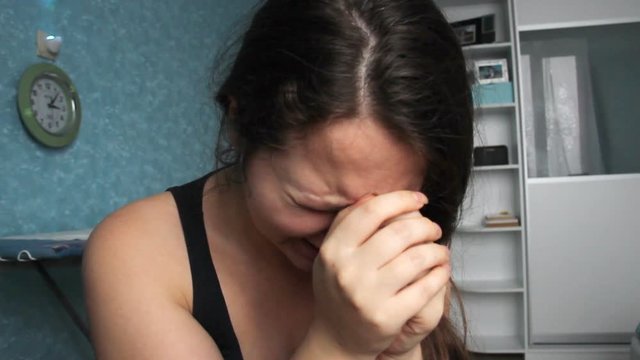 Woman desperate at home. Victim of Abuse Violence. Caucasian girl with long brown hair crying in her room with blue and white. Fat body with overweight. Postpartum Depression