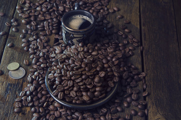 cups with hot coffee and grains on the board surface