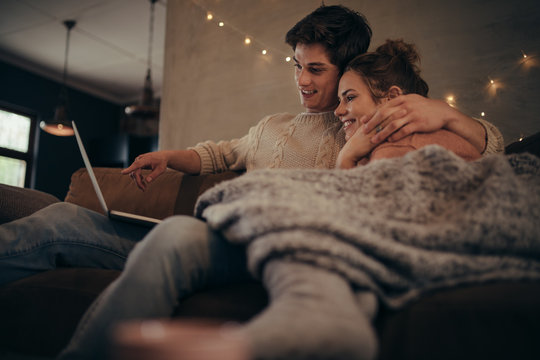 Love couple in hygge house with laptop