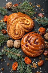 Homemade pastries for Christmas, decorations and dried fruits on a black background.