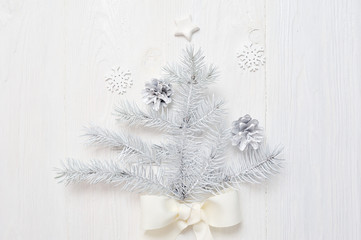 Fototapeta na wymiar Mockup Christmas white tree and cone. Flatlay on a white wooden background, with place for your text