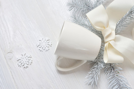 Mockup white cup on a wooden background, in Christmas decorations. The top view is photographed