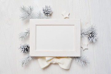 Fototapeta na wymiar Mockup Christmas greeting card top view and white frame, flatlay on a white wooden background with a ribbon, with place for your text