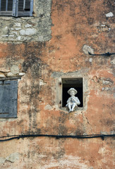 A figurine in the window of an old house