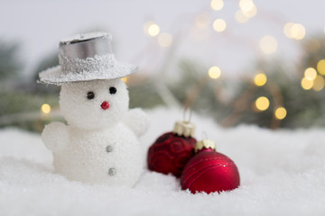 Schneemann mit Weihnachtskugeln im Schnee
