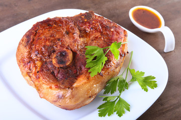 grilled pork chop with sauce on wooden table.