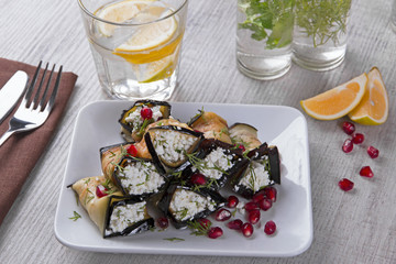 rolls of fried eggplant with cheese and pomegranate seeds