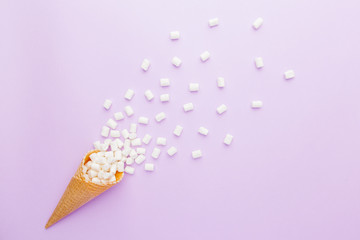 waffle cone and mini marshmallows on pink  background. Top view