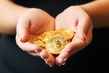 Gold coins bitcoin stacked in the palms hands of a young woman on a dark background close-up. Crypto currency. Anonymous                              