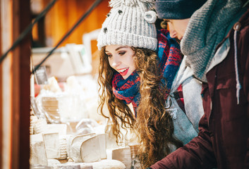 Obraz na płótnie Canvas Christmas market shopping, couple choosing things for buying