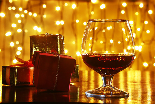 Whiskey, cognac, brandy and gift box on wooden table. Celebration composition on the light background.