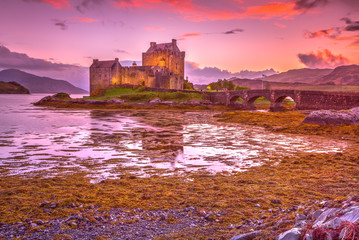 Magenta sunset at Eilean Donan Castle, Dornie, Kyle of Lochalsh in Scotland, United Kingdom. The...
