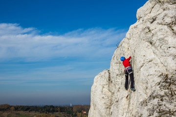 Female climbing a rock in Jura Krakowsko-Czestochowska, Silesia, Poland