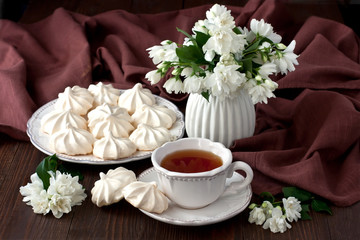 Composition with cookies, cup of tea  and jasmine flowers on wooden background