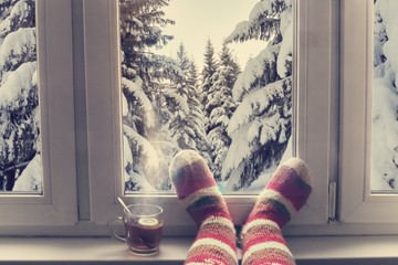 feet in wool knitted socks and a cup of steaming tea on the windowsill overlooking the winter snow...