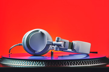 Player turntable vinyl records and white headphones in red light. Equipment for the disc jockey. Sound technology for DJ to mix and play music. Violet vinyl plate. Vinyl turntable in red light - 184482401