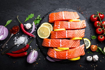 Fresh raw salmon red fish fillet on black background. Top view