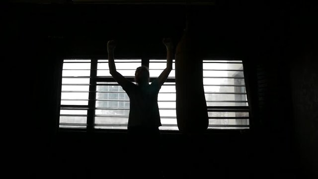 The athlete is happy with his luck. The boxer after the training rejoices at his success. The man raised his hands in a victorious cry