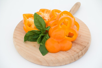 Freshness composition with orange bell pepper and basil on cutting board