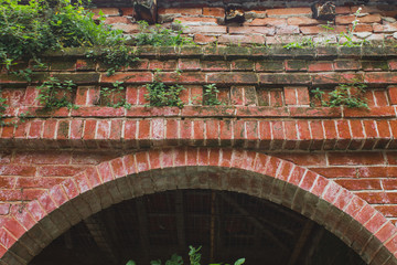 Fototapeta na wymiar Red brick arch with grass that supporting roof in Crespi d'Adda