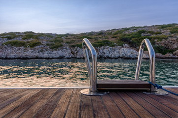 The rear deck of a sailing yacht, over the gorgeous waters of Arki island, Dodecanese, Greece 