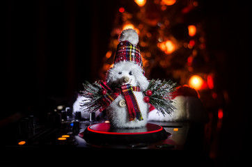 Dj mixer with headphones on dark nightclub background with Christmas tree New Year Eve. Close up...