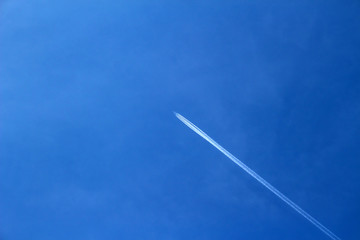 Trail from the plane in the blue sky