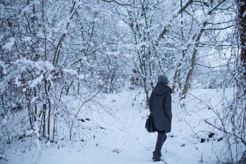 Girl walking in the winter forest