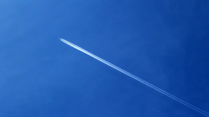 Trail from the plane in the blue sky