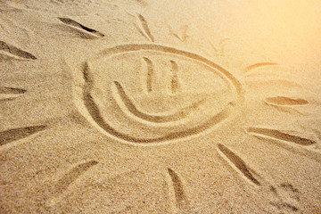 Fototapeta na wymiar Drawing of the sun on the sand