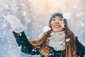 Winter young woman portrait. Beauty Joyful Model Girl laughing and having fun in winter park. Beautiful young woman outdoors. Enjoying nature, wintertime