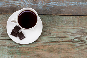 Cups of coffee with chocolate on wooden table with copy space