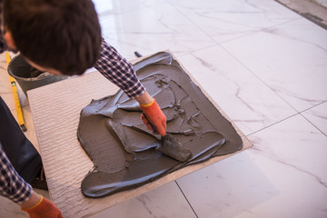 Laying Ceramic Tiles. Worker make preparation for laying floor tile.