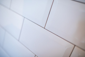 Stylish trendy white ceramic tile with a chamfer on the kitchen wall.