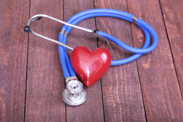 Heart with a stethoscope, isolated on wooden background